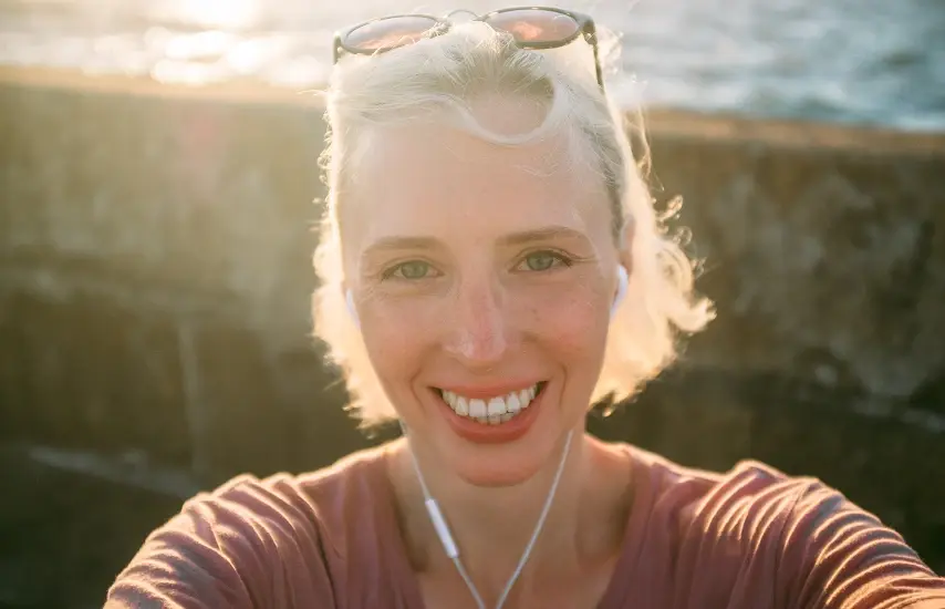 Femme avec des écouteurs au bord de la mer